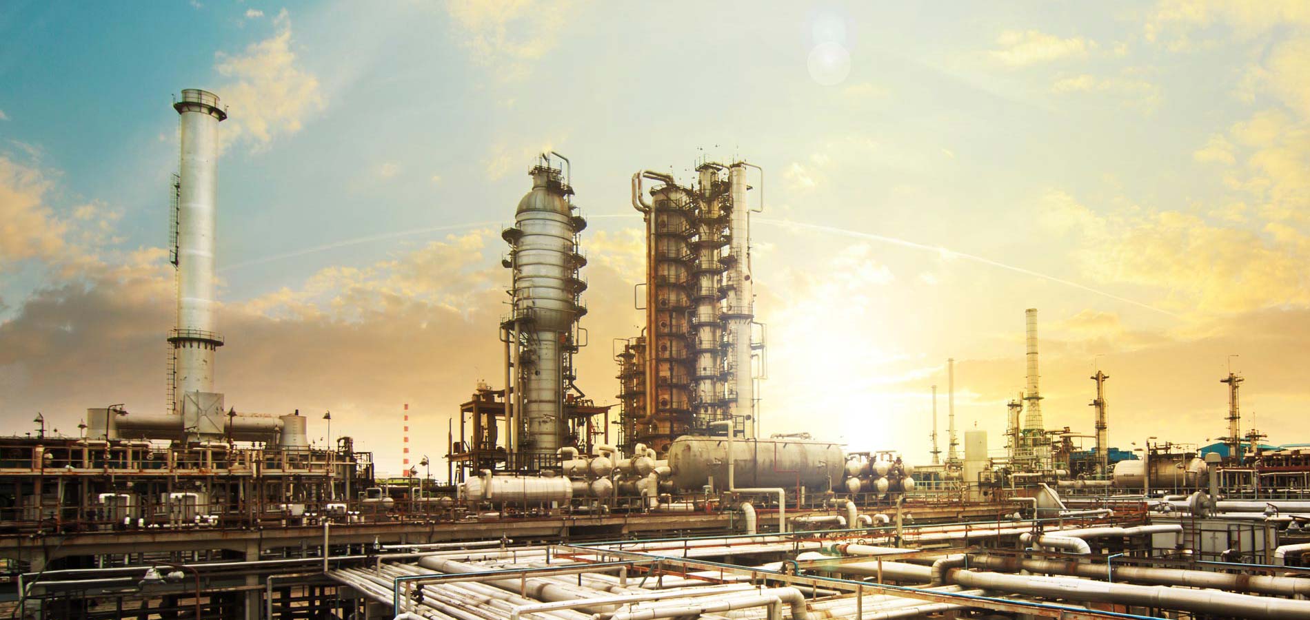 Process plant towers and piping at sunrise